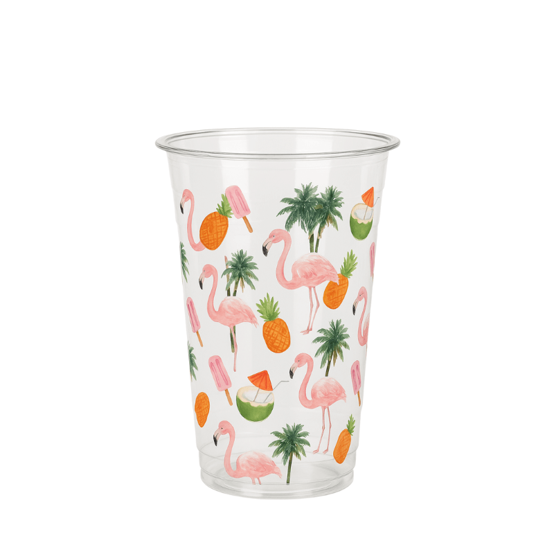 Clear plastic cup with a tropical pattern of pink flamingos, pineapples, palm trees, popsicles, and coconuts on a white background.