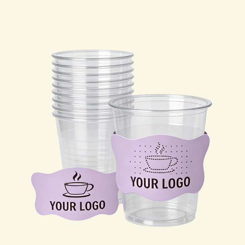 Stack of clear plastic cups with one cup wrapped in a purple shaped sleeve featuring a coffee cup icon and “YOUR LOGO,” plus a matching sleeve sample in front.
