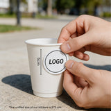 10oz double wall white paper cup with a logo sticker displayed on a wooden café counter.