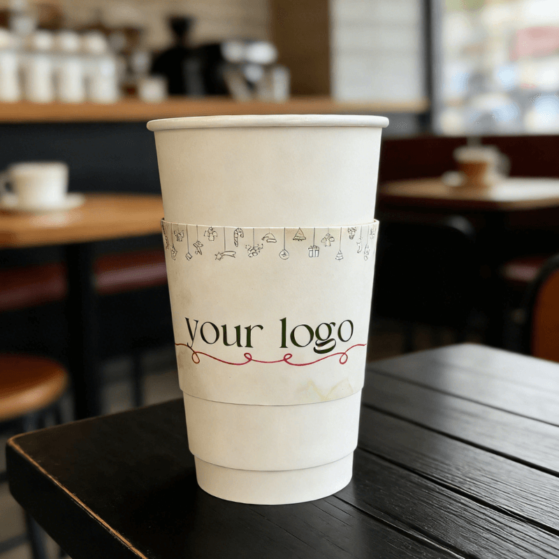 White paper cup with a minimal custom logo cup sleeve, accented with small doodle icons and a red wavy line.