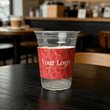 Clear plastic cup wrapped with a red watermelon-pattern cup sleeve featuring a customizable logo.