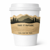 White paper cup with a kraft, mountain-shaped sleeve featuring a forest silhouette and the text “TAKE IT OUTSIDE.” and “FUEL FOR THE TRAIL.