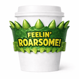 White paper cup with a green dinosaur-scale sleeve with spikes and the text “FEELIN’ ROARSOME!